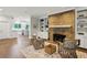Living room boasts a brick fireplace, built-in cabinets, hardwood floors, and a view into the kitchen at 8925 Huntcliff Lake Ct, Atlanta, GA 30350