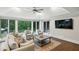 Sunroom with vaulted ceilings, a ceiling fan, hardwood floors, and walls of windows overlooking the backyard at 8925 Huntcliff Lake Ct, Atlanta, GA 30350