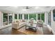Bright sunroom features hardwood floors, floor to ceiling windows, and a view of the pool and outdoor space at 8925 Huntcliff Lake Ct, Atlanta, GA 30350