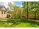 Large backyard with a shed, a black fence and surrounding green trees at 107 Estates At The Lake Dr, Canton, GA 30114