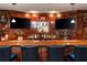 Home bar features a wooden bar top, two TVs, and seating for six at 107 Estates At The Lake Dr, Canton, GA 30114