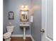 Stylish half bathroom features a pedestal sink, framed mirror, and updated lighting at 107 Estates At The Lake Dr, Canton, GA 30114