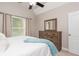 Bright bedroom featuring natural light, vaulted ceiling, and coordinated wood dresser with mirror at 107 Estates At The Lake Dr, Canton, GA 30114