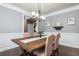 Bright dining room featuring hardwood floors, wainscoting, and stylish chandelier for elevated sophistication at 107 Estates At The Lake Dr, Canton, GA 30114