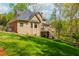 Back exterior view of a tan house with two levels of decks and green grass at 107 Estates At The Lake Dr, Canton, GA 30114