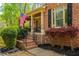 Charming front porch with brick steps, black railings, lush landscaping, and an American flag at 107 Estates At The Lake Dr, Canton, GA 30114