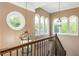 Hallway with elegant wood staircase and railing, decorative lighting, and arched windows at 107 Estates At The Lake Dr, Canton, GA 30114