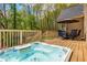 Relaxing hot tub on a wooden deck with outdoor seating and a view of the trees at 107 Estates At The Lake Dr, Canton, GA 30114