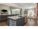 Open concept kitchen and living area boasts an island with granite counters, stainless appliances, and wood floors at 107 Estates At The Lake Dr, Canton, GA 30114
