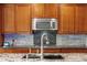 Well-lit kitchen features wooden cabinets, stainless steel appliances, granite countertops, and stylish backsplash at 107 Estates At The Lake Dr, Canton, GA 30114