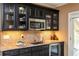 Stylish wet bar with granite countertops, stainless steel appliances, and tiled backsplash at 107 Estates At The Lake Dr, Canton, GA 30114