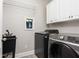 Modern laundry room with front load washer and dryer, utility sink, and white cabinets at 107 Estates At The Lake Dr, Canton, GA 30114