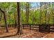 Wooden fence borders wooded lot line with lush trees surrounding the property at 107 Estates At The Lake Dr, Canton, GA 30114