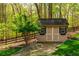 Storage shed with a stone path and green grass, surrounded by a wooded area at 107 Estates At The Lake Dr, Canton, GA 30114