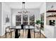 Bright dining room featuring modern light fixture, light wood floors, and multiple large windows at 2433 Idlewood Way, Snellville, GA 30078