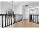 Upstairs hallway featuring hardwood floors, black railings, and natural light at 2433 Idlewood Way, Snellville, GA 30078