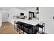 Eat-in kitchen showcasing breakfast bar, black accents, white cabinets, and stainless steel appliances at 2433 Idlewood Way, Snellville, GA 30078