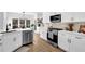 Open concept kitchen and dining area featuring white cabinetry, island, stainless steel appliances, and breakfast bar at 2433 Idlewood Way, Snellville, GA 30078