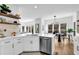Open concept kitchen and dining area featuring white cabinetry, island, stainless steel appliances, and breakfast bar at 2433 Idlewood Way, Snellville, GA 30078
