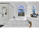 Bright main bathroom featuring a glass shower, soaking tub, and large window at 2433 Idlewood Way, Snellville, GA 30078