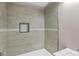 Bathroom shower and bath featuring light tile, a recessed storage area, and modern fixtures at 3457 Skyview Dr, Lithia Springs, GA 30122