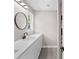Bathroom featuring a white countertop, basin sink and a round decorative mirror at 3457 Skyview Dr, Lithia Springs, GA 30122
