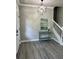 Stylish foyer featuring a staircase, modern light fixture, console table, and sleek gray wood flooring at 3457 Skyview Dr, Lithia Springs, GA 30122