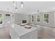 Spacious living room with hardwood floors, fireplace, large windows, and an adjacent modern kitchen at 3457 Skyview Dr, Lithia Springs, GA 30122