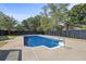 In-ground pool with concrete deck, ladder, and safety fence at 3457 Skyview Dr, Lithia Springs, GA 30122