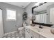 Contemporary bathroom with a modern vanity, black framed mirror, and stylish geometric flooring at 4965 Skyland Pkwy, Cumming, GA 30028