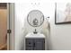 Modern half bath with a round mirror, gray vanity, and minimalist design at 4965 Skyland Pkwy, Cumming, GA 30028
