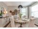 Dining area featuring a round table with six chairs, decorative wall hangings, and large window at 4965 Skyland Pkwy, Cumming, GA 30028