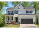 Charming two-story home with a covered front porch and a two-car garage in a leafy neighborhood at 4965 Skyland Pkwy, Cumming, GA 30028