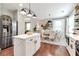Bright kitchen featuring a stainless steel refrigerator, island with white cabinets, and adjacent dining area at 4965 Skyland Pkwy, Cumming, GA 30028