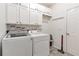 Well-lit laundry room featuring a side-by-side washer and dryer, white cabinets, and vinyl flooring at 4965 Skyland Pkwy, Cumming, GA 30028