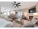 Open-concept living space with a fireplace, neutral sectional, and view of the kitchen at 4965 Skyland Pkwy, Cumming, GA 30028