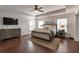 Spacious main bedroom with tray ceiling, hardwood floors, and two windows providing natural light at 4965 Skyland Pkwy, Cumming, GA 30028