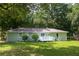 Green lawn and backyard with a deck, on a well-maintained home with mature trees at 879 Rock Oak Ln, Lawrenceville, GA 30046