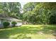 Large green lawn with a deck on a well-maintained home surrounded by mature trees at 879 Rock Oak Ln, Lawrenceville, GA 30046