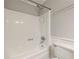 Bathroom featuring a white tub and shower with white tiling and fixtures at 879 Rock Oak Ln, Lawrenceville, GA 30046