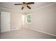 A bedroom with neutral walls, plush carpeting, and a view into an adjacent room through an open door at 879 Rock Oak Ln, Lawrenceville, GA 30046