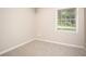Bedroom with neutral walls, plush carpeting, and a view of the outdoors through a window at 879 Rock Oak Ln, Lawrenceville, GA 30046