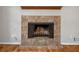 Close-up of a stone fireplace with a wood mantel and tile hearth, hardwood floors at 879 Rock Oak Ln, Lawrenceville, GA 30046