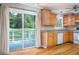 Kitchen with wood cabinets, tile backsplash, and sliding glass door to outdoor deck at 879 Rock Oak Ln, Lawrenceville, GA 30046