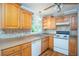 Kitchen with wood cabinets, tile backsplash, white appliances and window at 879 Rock Oak Ln, Lawrenceville, GA 30046