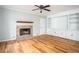 Bright living room featuring a stone fireplace, built-in shelving, and hardwood floors at 879 Rock Oak Ln, Lawrenceville, GA 30046