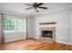 Living room with a stone fireplace, large window, hardwood floors, and neutral walls at 879 Rock Oak Ln, Lawrenceville, GA 30046