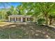 Charming single-story home with white siding, black shutters, and a well-maintained front yard with mature trees at 144 Cathy Ln, Hiram, GA 30141