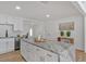 Bright kitchen features white cabinets, subway tile backsplash, and a granite island with gold hardware at 144 Cathy Ln, Hiram, GA 30141