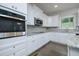 Close-up of a modern kitchen featuring stainless steel appliances, white cabinets, and granite countertops at 247 Lotus Ln, Covington, GA 30016